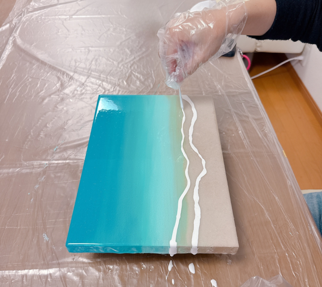 白いレジンで波を描いていく海レジンアート